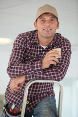 man on a ladder drinking a coffee
