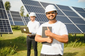 Two engineers or businessmen on the background of solar panels. Renewable energy. Green energy