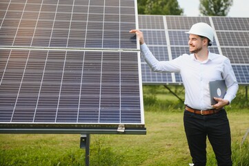 Male engineer in glasses and formal white shirt monitoring system of solar panels