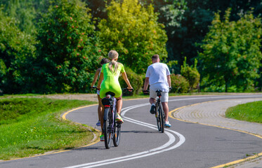 Obraz premium Cyclists ride on the bike path in the city Park