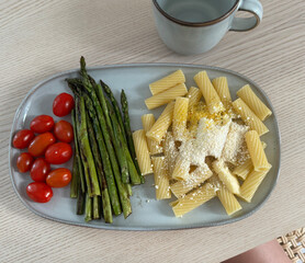 Delicious pasta with asparagus and cherry tomatoes served on a plate