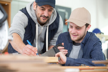 portrait of carpenter cutting wood while working in joinery workshop