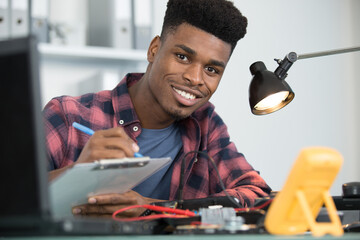 computer technician making notes on a clipboard
