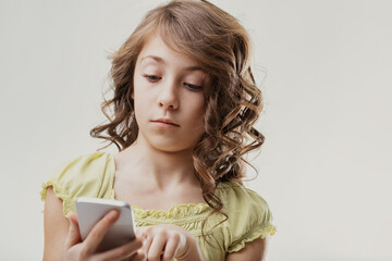 Young girl using smartphone with a pensive expression