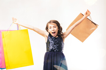 Excited girl holding shopping bags with open arms