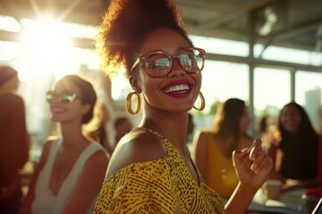 A fashionable black woman smiling at an event under warm sunlight wearing sunglasses