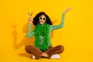 Young woman with curly hair in summer casual clothes celebrating against yellow background