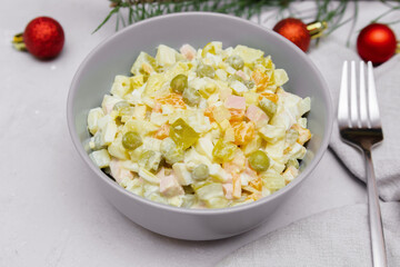 Olivier salad,Christmas food.salad with chicken and vegetables,pea.Traditional ukrainian slavic appetizer recipe for celebrating new year's eve. Festive table setting with decoration.