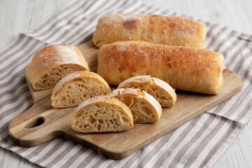 Homemade Sliced Ciabatta Bread on a wooden board, side view.