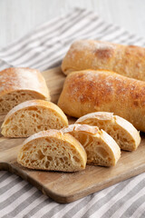 Homemade Sliced Ciabatta Bread on a wooden board, side view.