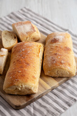 Homemade Sliced Ciabatta Bread on a wooden board, side view.