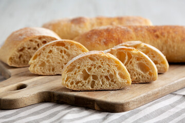 Homemade Sliced Ciabatta Bread on a wooden board, low angle view. Close-up.