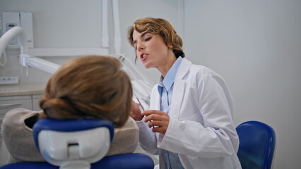 Obraz premium Dentist providing oral examination in dentistry office closeup. Woman doctor 