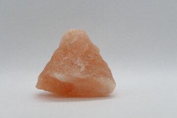 A close-up of Himalayan pink salt or halite rock isolated on a white background 