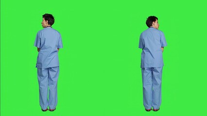 Stressed nurse being in a hurry with the checkup appointments, waiting for patients to arrive at examinations. Medical assistant with scrubs acting impatient against greenscreen backdrop. Camera A.