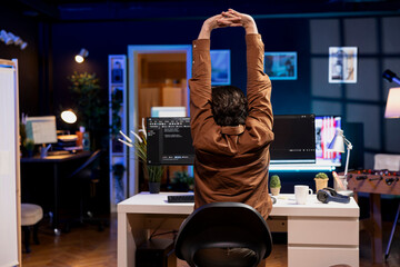 Developer doing software quality assurance, stretching after reading source code, feeling tired. IT...