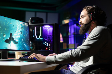 Man using gaming keyboard and headphones to play spaceship flying game with overlay HUD showing health, fuel bars. Gamer wearing headset navigating with spacecraft in galaxy, shooting at asteroids