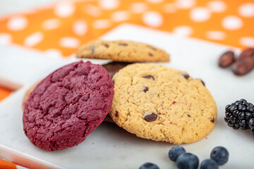 Cookie, Close-up of oatmeal cookies with raisins and chocolate on a plate in warm colors with a blurred background. Healthy Food Snack Concept.