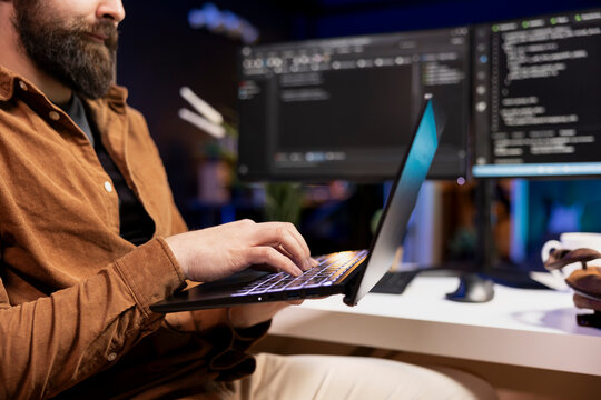 Admin in apartment typing on laptop to fix vulnerabilities in software enabling attackers to compromise systems. Cybersecurity specialist taking care of security exposures, close up