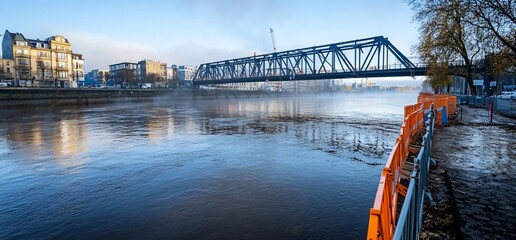 Steel bridge over river, foggy morning.