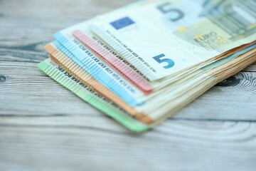 Big amount of different denominations of euro money bills on wooden background