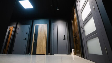 Modern showroom displaying a variety of interior and entry doors, including frosted glass, wooden, and minimalist designs