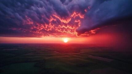 Obraz premium A stunning sunset over rolling hills, with dramatic clouds and vibrant colors.