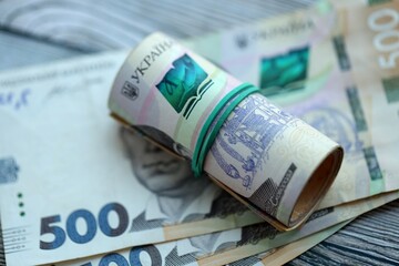 Many five hundred hryvnia money bills lies on wooden background. Ukrainian national currency close up