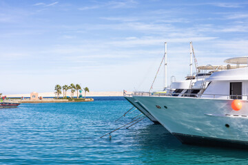 Luxurious yachts moored in a tranquil marina with clear blue waters