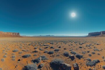 Obraz premium Wide desert landscape under a bright sun in a clear blue sky during midday