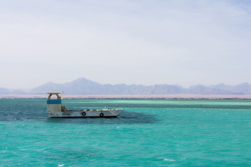 Tranquil seascape with lone boat and distant mountains for travel and adventure themes