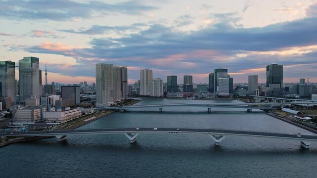 tokyo city skyline aerial shot drone at dawn flying over koto ku ward odaiba harumioashi bridge
