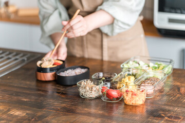 キッチンでお弁当を作る女性の手元
