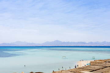 Serene coastal landscape with tranquil blue waters and distant mountains