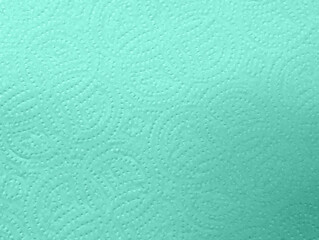 Close-up macro view of turquoise embossed kitchen paper towel texture details with circular patterns design. Soft textured absorbent material for households cleaning and wiping surfaces efficiently.