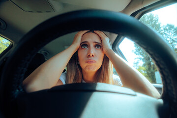 Overwhelmed Stressed Female Driver Behind the Wheel. Unhappy woman driving a car causing an...