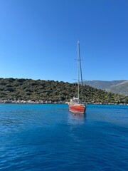 Fototapeta premium Sailing in crystal clear waters near a lush green island under a bright blue sky