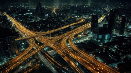 Aerial view of a bustling city with illuminated highways and skyscrapers at night.