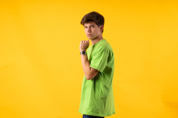 Young person expressing various emotions and body pains, pointing, using a cellphone, with colored backgrounds and wearing shirts of different colors