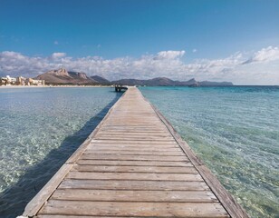 Obraz premium The wooden pier on the beach provides a calm and natural atmosphere, stretching from the white sand to the clear blue sea water.