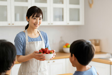 家族にイチゴを差し出す主婦