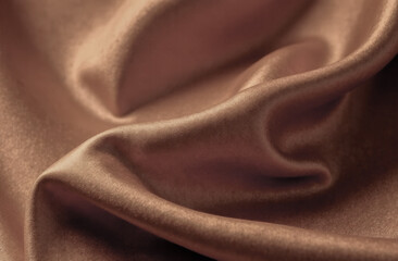 close-up of soft waves of silky fabric in trendy mocha mousse color