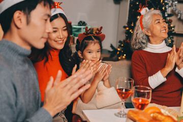 Happy multigeneration family enjoying in opening gifts on Christmas eve at home.