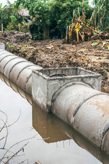 Large water pipes are laid in ditches for drainage system installation,supported by excavators.This...