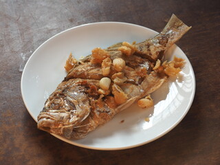fried whole False Trevally fish with garlic