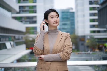 Confident Young Businesswoman Engaging in a Phone Conversation Outdoors