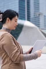 Young Professional Woman Engaged with Tablet in Modern Urban Setting