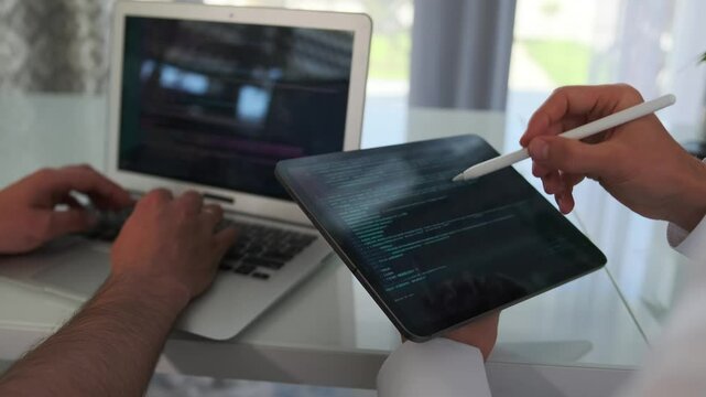Team improves the app, fixing code on a laptop.