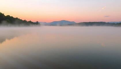 Serene Sunrise Fog Over Misty Lake and Mountains