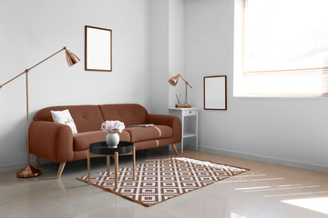 Comfortable sofa and modern lamps near white wall